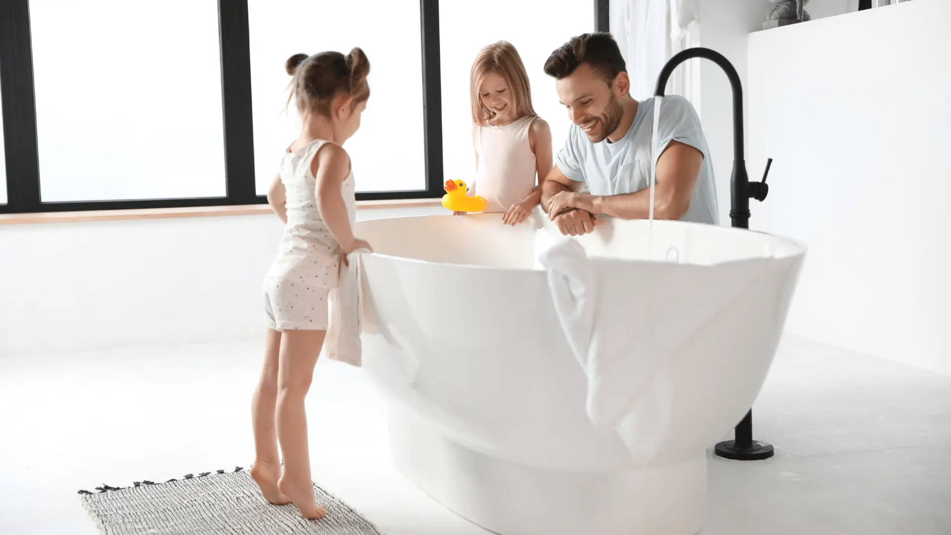 Un père et ses deux filles, en train d'utiliser une baignoire