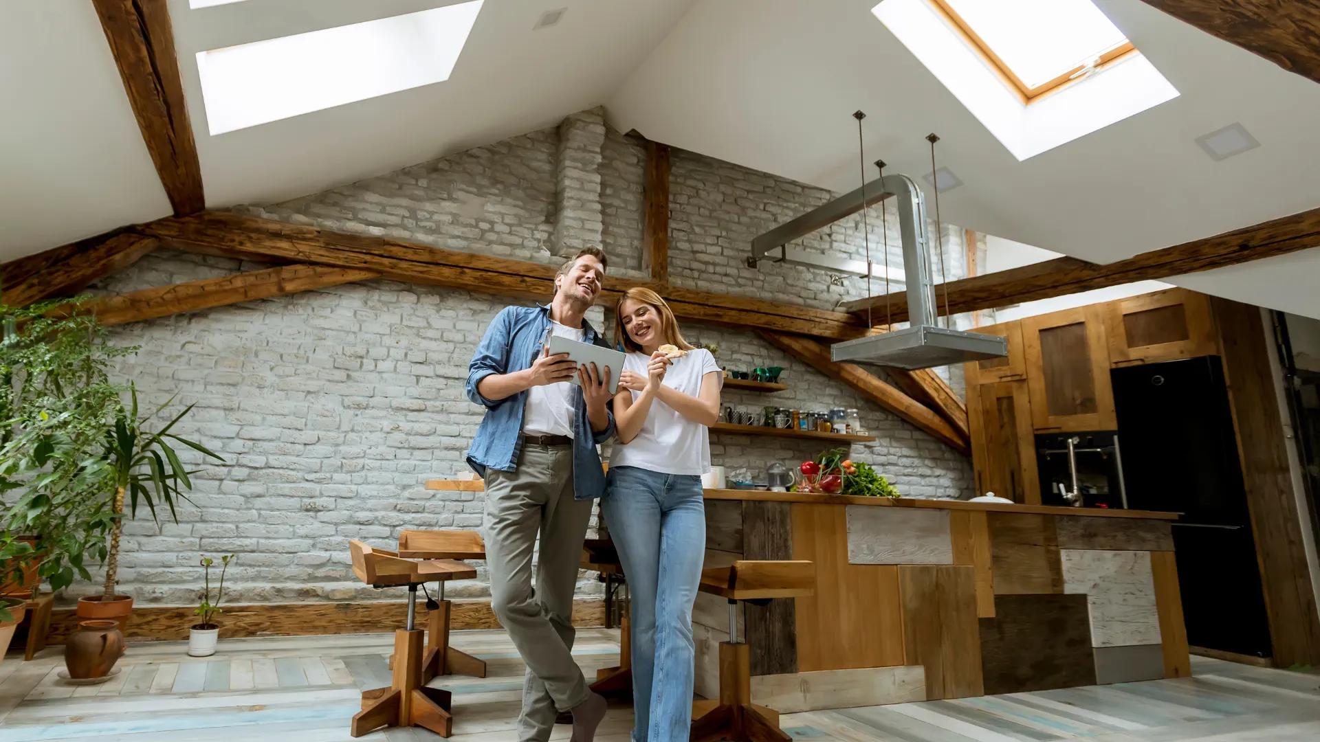 couple dans leurs piece de vie sous toiture apres isolation des combles